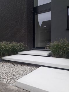 the steps lead up to the front door of this modern house