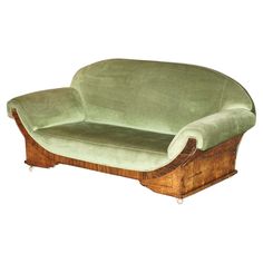 a green couch sitting on top of a wooden frame