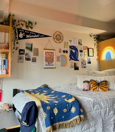 a room with a bed, bookshelf and pictures on the wall above it