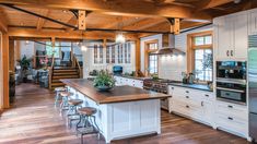 a kitchen with an island, stove and refrigerator freezer next to a staircase leading up to the second floor