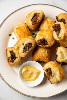 a white plate topped with pastries covered in meat