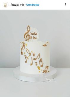 a white and gold cake with musical notes on it