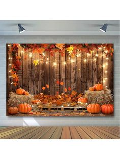 an autumn scene with pumpkins and hay bales in front of a wooden fence