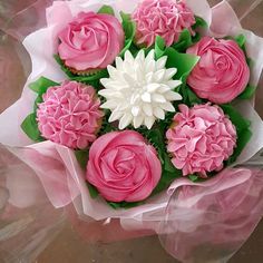 a bouquet of pink and white cupcakes in plastic wrap