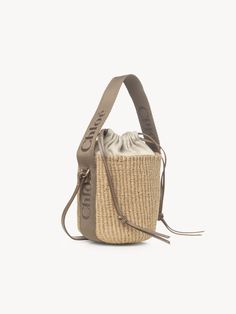 Chloé Small Woody Basket In Fair Trade Natural Fibers | Chloé US Eco-friendly Bucket Bag With Braided Handles, Straw Pouch Bag With Braided Handles For Shopping, Shopping Straw Pouch Bag With Braided Handles, Braided Handles Straw Pouch Bag For Shopping, Woven Straw Pouch Bag For Shopping, Leather Crochet Bucket Bag With Braided Handles, Natural Fiber Bucket Bag, Basket-shaped Bucket Bag With Woven Leather For Shopping, Basket-shaped Woven Leather Bucket Bag For Shopping