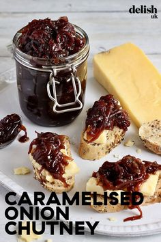 jam and crackers sit on a plate next to a jar of butter, cheese and jelly