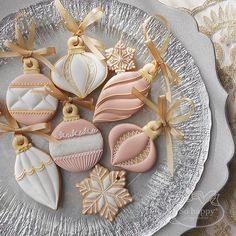 decorated christmas cookies on a plate with bows and ribbon around the edges, including one ornament