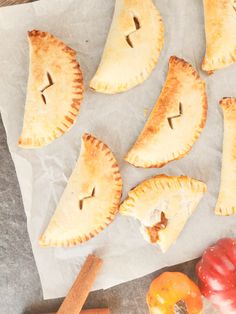 several pieces of pie sitting on top of a piece of wax paper next to some vegetables