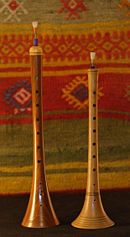 two flutes are sitting side by side in front of a colorful background with the word zuma written on it