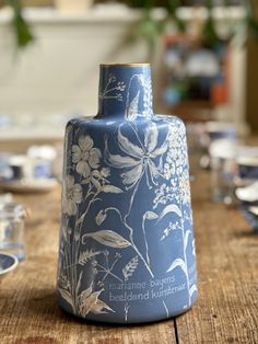 a blue vase sitting on top of a wooden table