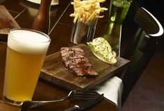 a wooden table topped with steak and fries