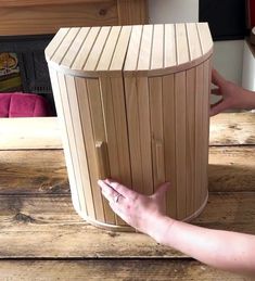 a woman is opening the door to a wooden hot tub