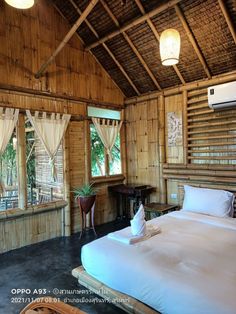 a bed sitting inside of a bedroom next to a window covered in bamboo blinds and curtains