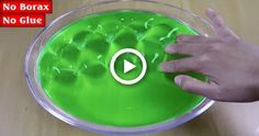 a person is mixing green liquid in a bowl with their hand on the top of it