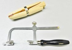 a pair of scissors and a clamp on a white surface