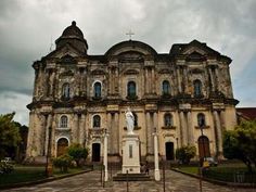 an old church with people walking around it