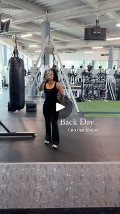 a woman standing in the middle of a gym with a punching bag on her chest