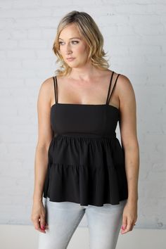 Make an entrance wearing the striking Malia Babydoll Blouse. + Woven Fabric + Double Spaghetti Strap Detail + Babydoll Waistline + Zipper Closure Back + Ruffle Tier Detail on Body #tank #heat #hotweather #beattheheat #summerfit #warmweather #layering Tiered Blouse, Babydoll Blouse, Body Colour, Black Tank, Hot Weather, Black Blouse, Warm Weather