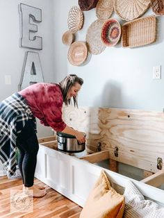 a woman is washing dishes in the kitchen