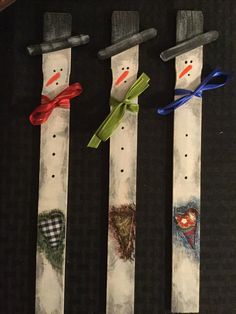 three snowmen made out of skis with bows