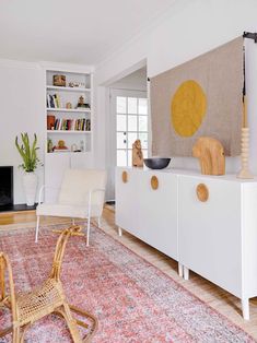 a living room filled with furniture and a large rug on top of a hard wood floor