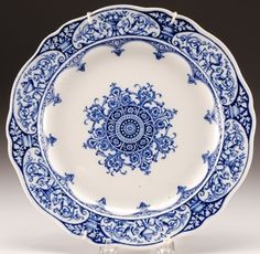 a blue and white plate on a stand