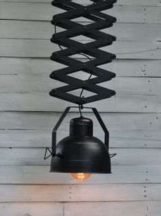 a black light hanging from the side of a wooden wall with a spiral design on it