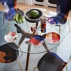 a glass table topped with plates and bowls