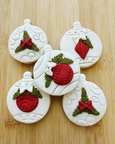 four decorated cookies sitting on top of a wooden table