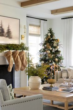 a living room with a christmas tree and stockings hanging from the fireplace mantels