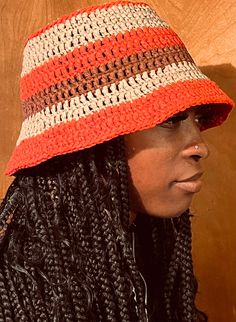 a close up of a person wearing a hat with dreadlocks and braids