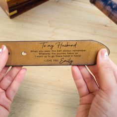 two hands holding a leather bookmark with the words to my husband written on it