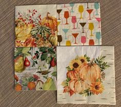 four napkins decorated with fall fruits and wine glasses on top of a table cloth