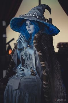 a woman with blue hair wearing a witches hat