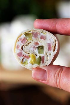 a hand holding a piece of food in it's left side and the other end of its wrap