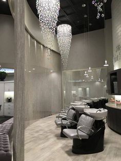 a salon with chairs and chandeliers hanging from the ceiling