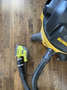 a yellow and black corded sander sitting on top of a hard wood floor