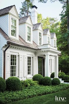 a white house with many windows and bushes