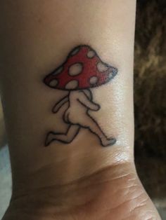 a small mushroom tattoo on the wrist