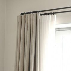 an open window with curtains hanging on the side and a curtain rod attached to it