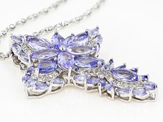 6.23ctw marquise and .12ctw round tanzanite with .31ctw round white diamond and .05ctw round blue diamond rhodium over sterling silver cross pendant with 24" singapore chain. Measures approximately 1.75"L x 1.29"W. Lobster clasp. 3mm bail. 2" extender. Finished back. White Gold Tanzanite Jewelry With Diamond Accents, Diamond White Multi-stone Marquise Jewelry, Diamond White Marquise Multi-stone Jewelry, Silver Tanzanite Jewelry With Diamond Accents, Dazzling Tanzanite Jewelry With Diamond Accents, Marquise Diamond Jewelry With Gemstone Accents, Purple Diamond Marquise Jewelry, Silver Marquise Jewelry With Gemstone Accents, Purple Marquise Diamond Jewelry