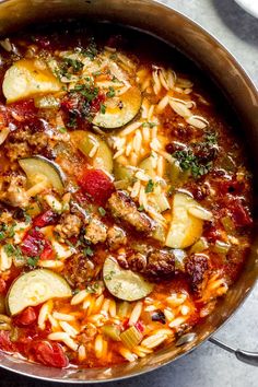 a pot filled with pasta and vegetables on top of a table