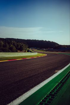 an aerial view of a race track with trees in the backgrouds and blue sky