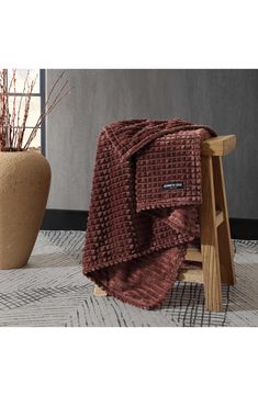 a brown blanket sitting on top of a wooden stool