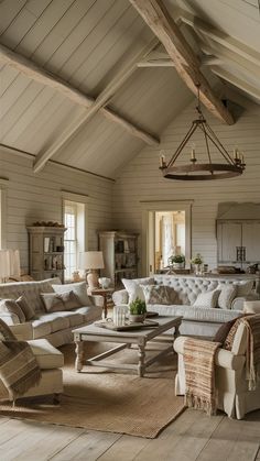 a living room filled with furniture and a chandelier hanging from the ceiling above