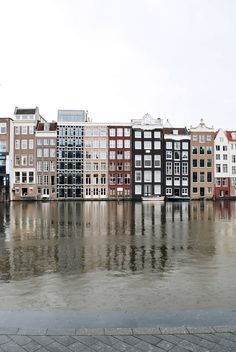 a row of buildings sitting next to each other on top of a body of water