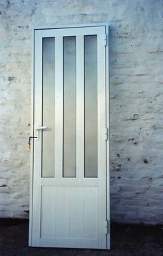 a white door sitting next to a brick wall