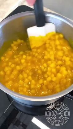 a pan filled with yellow food sitting on top of a stove next to a burner