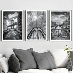 three black and white pictures hanging on the wall above a couch in a living room