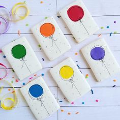 four coasters with balloons painted on them and confetti sprinkles